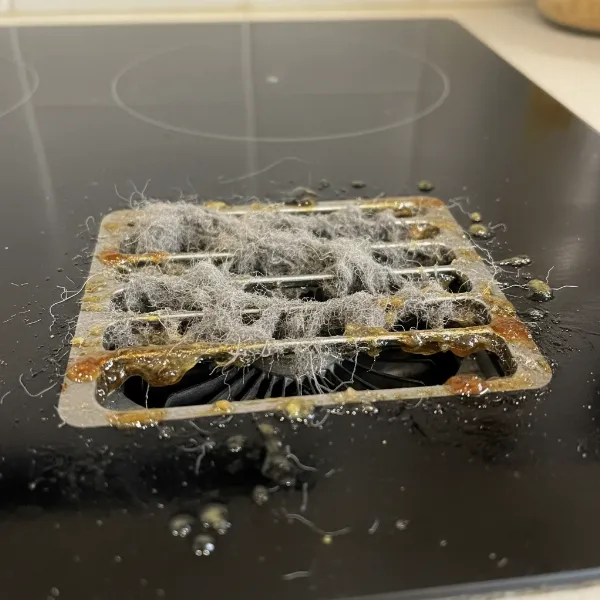 Close-up of a cooktop's vents showing dust and grease buildup, indicating maintenance is needed